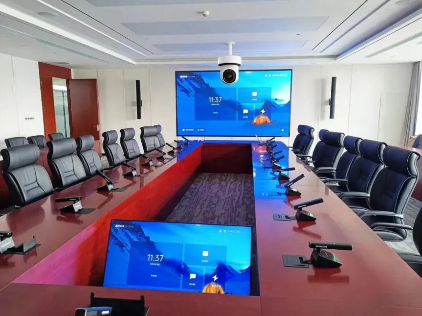 اتاق کنفرانس مجهز به دوربین ویدئوکنفرانس سقفی، میکروفن کنفرانس و نمایشگرهای سیتاچ روی میز جلسه